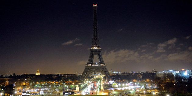 PARIS, FRANCE - JANUARY 08: As a tribute for the victims of yesterday's terrorist attack the lights of the Eiffel Tower were turned off for five minutes at 8pm local time on January 8, 2015 in Paris, France. Twelve people were killed yesterday including two police officers as two gunmen opened fire at the offices of the French satirical publication Charlie Hebdo. on January 8, 2015 in Paris, France. (Photo by Aurelien Meunier/Getty Images)