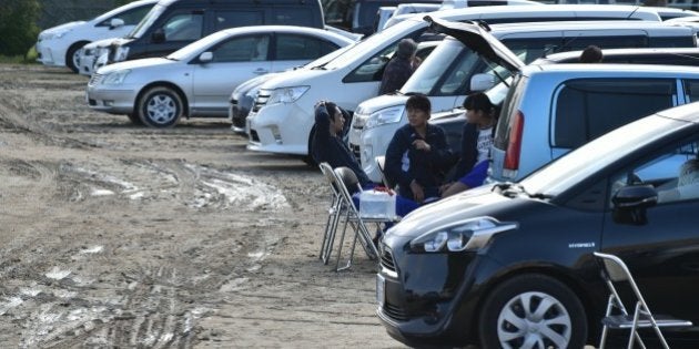 Earthquake-affected evacuees rest near their vehicles at a temporary parking lot in Mashiki, Kumamoto prefecture on April 17, 2016. Rescuers were racing against the weather and the threat of more landslides April 17 to reach people still trapped by two big earthquakes that hit southern Japan. / AFP / KAZUHIRO NOGI (Photo credit should read KAZUHIRO NOGI/AFP/Getty Images)