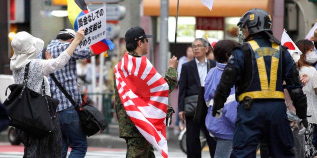 In this photo taken Sunday, May 19, 2013, nationalist protesters march through a Tokyo street to denounce