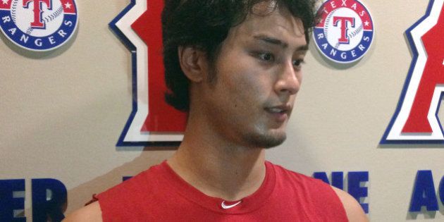Texas Rangers' Yu Darvish, of Japan, talks with reporters outside the clubhouse before the Rangers' baseball game against the Toronto Blue Jays on Tuesday, Aug. 25, 2015, in Arlington, Texas. (AP Photo/Stephen Hawkins