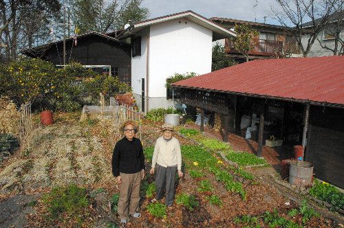 ●庭の畑に立つ津端修一さん（左）と妻の英子さん＝2009年1月、愛知県春日井市（朝日新聞）