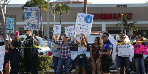 WEST PALM BEACH, FL - FEBRUARY 12: Protesters line the road as they wait for President Donald Trump to pass by February 12, 2017 in West Palm Beach, Florida. Trump is returning to Palm Beach International airport after meeting with Prime Minister Shinzo Abe of Japan at the Mar-a-Lago resort. (Photo by Joe Raedle/Getty Images)