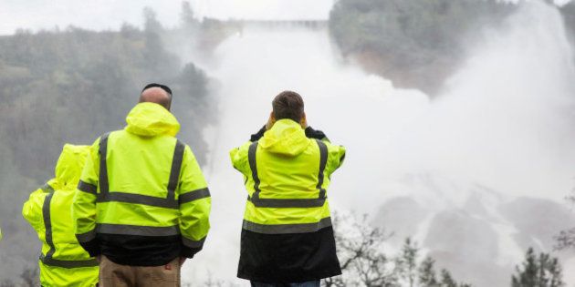 California Department of Water Resources personnel monitor water flowing through a damaged spillway on the Oroville Dam in Oroville, California, U.S., on February 10, 2017.