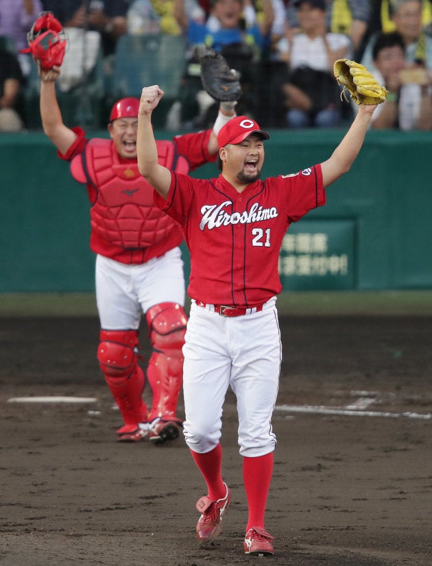 優勝を決め、喜ぶ広島の中崎（手前）と石原＝18日、甲子園