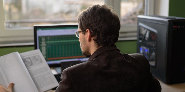 young businessman, student trying to solve problem, working on computer - stock photo