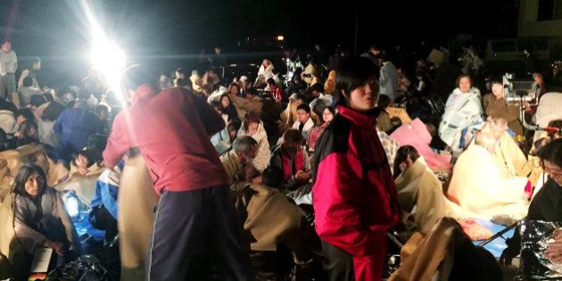 TOPSHOT - Residents gather for shelter in front of the town hall following an earthquake at Mashiki town in Kumamoto prefectuire on April 14, 2016. The strong 6.4-magnitude earthquake struck at 9:26 pm (1226 GMT) in Kumamoto, central Kyushu at a relatively shallow depth of 10 kilometres (6.2 miles), the Japan Meteorological Agency said. ==JAPAN OUT== / AFP / JIJI PRESS / JIJI PRESS (Photo credit should read JIJI PRESS/AFP/Getty Images)