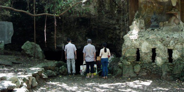 チビチリガマの洞窟入り口付近に祈りに訪れた人々＝9月18日午後、沖縄県読谷村