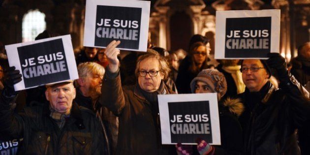 People hold placards reading in French 'I am Charlie' during a gathering in front of the prefecture in Lille, northern France, on January 7, 2015, following an attack by unknown gunmen on the offices of satirical weekly Charlie Hebdo. Heavily armed men shouting 'Allahu Akbar' stormed the Paris headquarters of a satirical weekly on January 7, killing 12 people in cold blood in the worst attack in France in decades. AFP PHOTO / DENIS CHARLET (Photo credit should read DENIS CHARLET/AFP/Getty Images)