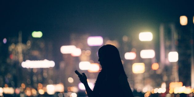 Silhouette of office lady using smartphone in city