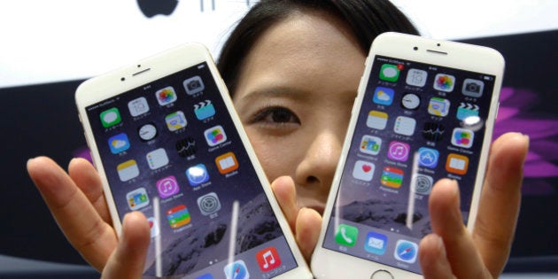 FILE - In this Sept 19, 2014 file photo, a customer shows off the new Apple iPhone 6, right, and 6 Plus at a store in Tokyo. Apple sold 61 million iPhones in the first three months of 2015, or 40 percent more than in the same period a year ago. That represented about two-thirds of its $58 billion in revenue. (AP Photo/Shizuo Kambayashi, File)