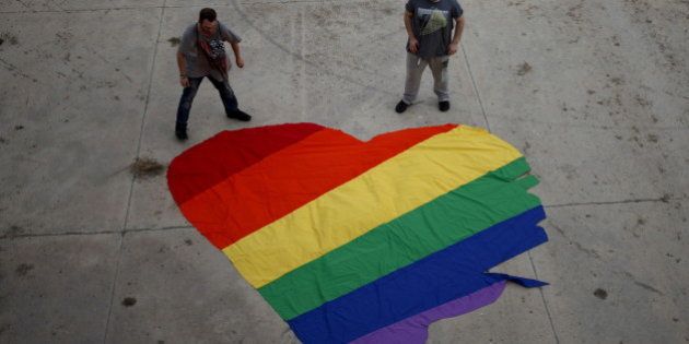 Fer Franco, 25, (R) and his partner Rafa Varon, 23, stand next to a heart-shaped cloth with rainbow colors as they pose for a photo, to mark Gay Pride day, in downtown Malaga, southern Spain, June 28, 2015. The heart-shaped cloth with rainbow colors is the logo of the Andalusian Federation of Lesbian, Gay, Bisexual, Transgender and Intersex (LGBTI) Arco Iris, which Franco and Varon are volunteers of. REUTERS/Jon Nazca