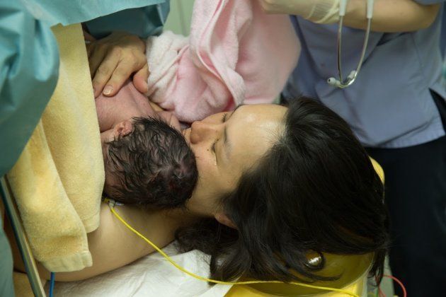緊急帝王切開後、赤ちゃんを抱きしめて涙する母。