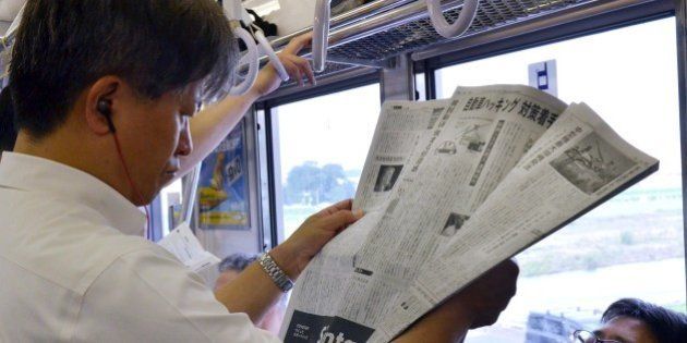 A man reads Japan's business daily newspaper, the Nikkei or Nihon Keizai Shimbun, in Tokyo on July 24, 2015. British publisher Pearson said it had agreed to sell its salmon-pink business newspaper the Financial Times to Japanese media group Nikkei for 160 billion yen (1.3 billion USD). AFP PHOTO / Yoshikazu TSUNO (Photo credit should read YOSHIKAZU TSUNO/AFP/Getty Images)