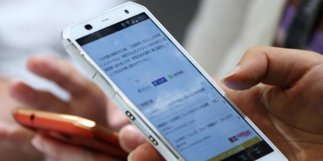 Attendees try out Fujitsu Ltd. Arrows smartphones during a news conference unveiling NTT Docomo Inc.'s new smartphone models in Tokyo, Japan, on Tuesday, Sept. 30, 21014. NTT Docomo, Japan's largest mobile phone company, introduced 16 mobile devices for winter and spring today. Photographer: Tomohiro Ohsumi/Bloomberg via Getty Images