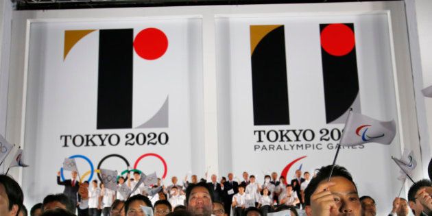 FILE - In this July 24, 2015 file photo, visitors wave flags in front of the official emblems of the Tokyo 2020 Olympics and Paralympic Games at Tokyo Metropolitan Plaza in Tokyo. Tokyo Olympic organizers are expected to scrap the logo for the 2020 Games on Tuesday, Sept. 1, 2015 following another allegation its Japanese designer might have used copied materials in presentations of the design. (AP Photo/Shizuo Kambayashi, File)