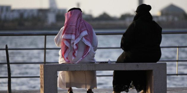 In this Sunday, May 11, 2014 photo, a Saudi couple sit on a bench overlooking the sea, in Jiddah, Saudi Arabia. A growing number of Saudi women are remaining single through their 20s and into their 30s as they pursue their ambitions, sending ultraconservatives into a panic. Traditionally, women in Saudi Arabia are expected to be married by their early twenties. Women are also challenging the rules on how to meet a prospective husband. (AP Photo/Hasan Jamali)