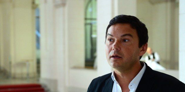 French economist and author Thomas Piketty speaks to journalists as he poses for a photographer following a discussion with German Vice Chancellor, Economy and Energy Minister at the Economy Ministry in Berlin November 7, 2014. AFP PHOTO / JOHN MACDOUGALL (Photo credit should read JOHN MACDOUGALL/AFP/Getty Images)