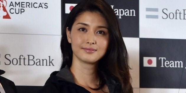 Softbank Team Japan general manager Kazuhiko Sofuku (L) smiles with Japanese actress Manami Hashimoto next to a scale model of a Team Japan yacht which was used at 2000 America's Cup races during a press conference at the Softbank headquarters in Tokyo on April 30, 2015, after the Japanese mobile giant announced an agreement with the Kansai Yacht Club to race in Bermuda, bringing to an end an absence from sailing's America's Cup in 2017 that began after the 2000 edition. Reigning champions Oracle will provide some support to SoftBank Team Japan in their preparations for this year's America's Cup World Series events, the next of which takes place in July at Portsmouth, England. AFP PHOTO / Yoshikazu TSUNO (Photo credit should read YOSHIKAZU TSUNO/AFP/Getty Images)