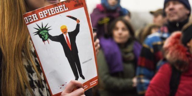 A young woman holds the last edition of 'Der Spiegel' magazine with a cover designed by Edel Rodriguez, as she protests against the travel ban imposed by US President Donald Trump, on February 4, 2017, in Berlin. / AFP / ODD ANDERSEN (Photo credit should read ODD ANDERSEN/AFP/Getty Images)