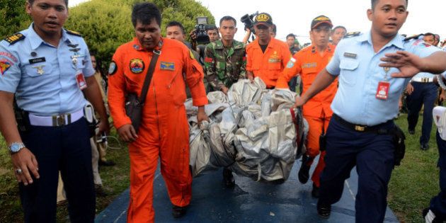 PANGKALAN BUN, INDONESIA - DECEMBER 30: Members of the Indonesian air forces carry items retrieved from the Java Sea during search and rescue operations for the missing AirAsia flight QZ8501 in Pangkalan Bun, Central Kalimantan on December 30, 2014. The authorities announced that more than 40 dead bodies of AirAsia victims were found and items resembling an emergency slide, plane door and other objects, which are confirmed as the debris of the plane by the airline, were spotted in the sea during an aerial search on December 30 for missing AirAsia flight QZ8501. (Photo by Yanuar Ikhwan/Anadolu Agency/Getty Images)