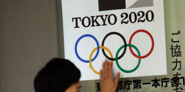 A visitor touches a logo of Tokyo Olympic Games 2020 at the Tokyo Metropolitan Government building in Tokyo Tuesday, Sept. 1, 2015. Tokyo Olympic organizers on Tuesday decided to scrap the logo for the 2020 Games following another allegation its Japanese designer might have used copied materials. (AP Photo/Eugene Hoshiko)
