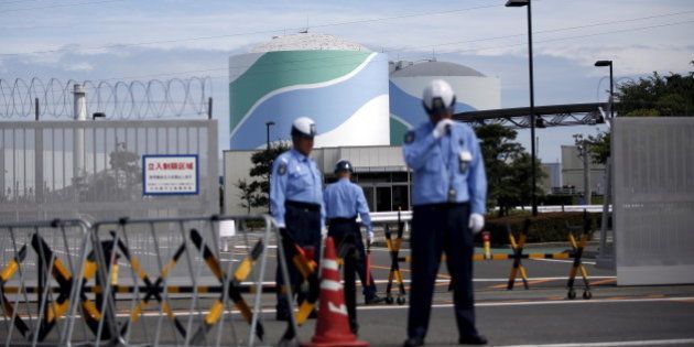 Security officers stand guard in front of an entrance gate of Kyushu Electric Power's Sendai nuclear power station in Satsumasendai, Kagoshima prefecture, Japan, July 8, 2015. Kyushu Electric Power Co started loading uranium fuel rods into a reactor on Tuesday, marking the first attempt to reboot Japan's nuclear industry in nearly two years after the sector was shutdown following the 2011 Fukushima disaster. REUTERS/Issei Kato