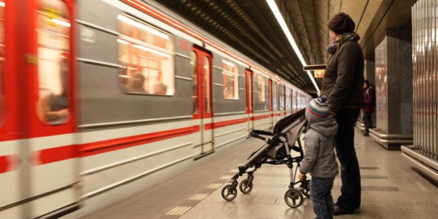 Family looking at train at subway station in Prague