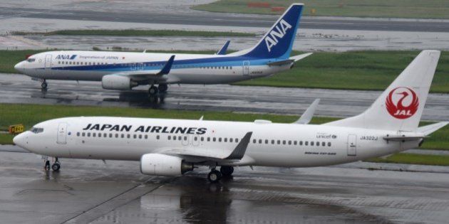 All Nippon Airways (ANA/top) and Japan Airlines (JAL/bottom) aircraft are seen at Haneda Airport in Tokyo on April 28, 2016. The Japanese airline will announce its financial results for fiscal year 2015 ended March 2016. / AFP / TORU YAMANAKA (Photo credit should read TORU YAMANAKA/AFP/Getty Images)