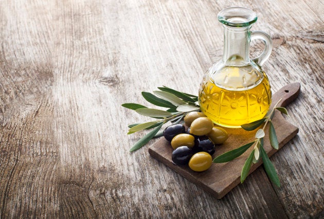 Olive oil and olive branch on the wooden table