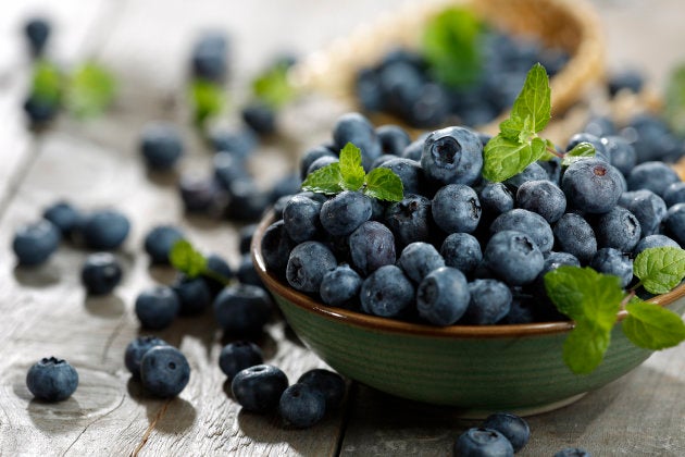 Full of blueberries close at the wooden table