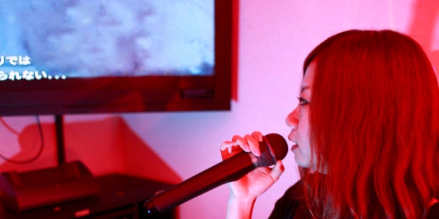 A young Japanese girl sings inside a Karaoke box, in Shibuya, Tokyo, Japan (Adobe RGB)