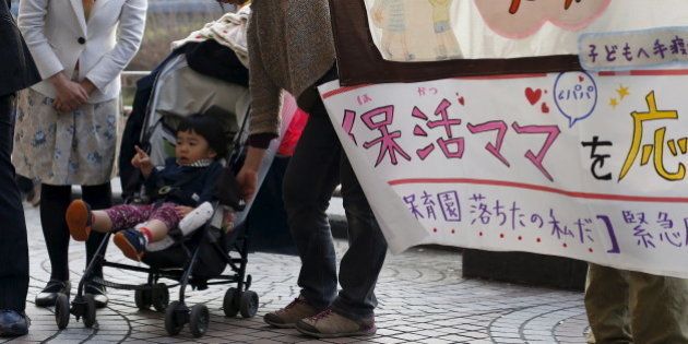 Two-year-old Amane Morohoshi sits in a baby stroller during a rally in support of mothers and fathers whose children failed to secure places at day care centres, in central Tokyo, Japan, March 20, 2016. REUTERS/Yuya Shino