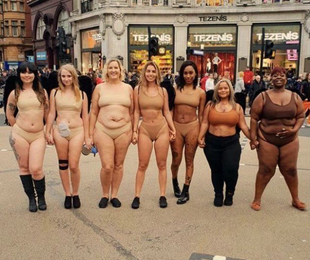 ロンドンにあるヴィクトリアズ・シークレットの前で、ヌードカラーの下着で立つ7人の女性たち