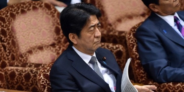 Japanese Prime Minister Shinzo Abe listens to a question by an opposition lawmaker at the Upper House's budget committee session at the National Diet in Tokyo on August 24, 2015. Abe will not visit China next month as he faces parliamentary backlash over his bid to expand the role of the military. Earlier this month, Abe repeated a desire to meet Chinese President Xi Jinping in early September, but was not expected to attend a huge Beijing military show of strength to commemorate the 70th anniversary of Japan's defeat in World War II. AFP PHOTO / Yoshikazu TSUNO (Photo credit should read YOSHIKAZU TSUNO/AFP/Getty Images)