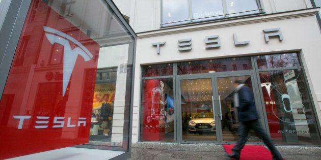 A pedestrian passes a Tesla Motors Inc. electric automobile showroom in Berlin, Germany, on Wednesday, Jan. 7, 2015. As European Central Bank policy makers gather for their first meeting of 2015 today, the backdrop is a 0.2 percent annual drop in consumer prices, the first in more than five years. Photographer: Krisztian Bocsi/Bloomberg via Getty Images
