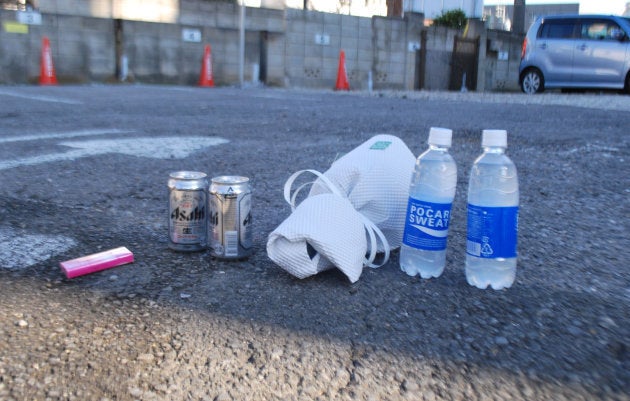 火災現場のビルと隣接する駐車場に置かれた花束や飲み物=18日、さいたま市大宮区