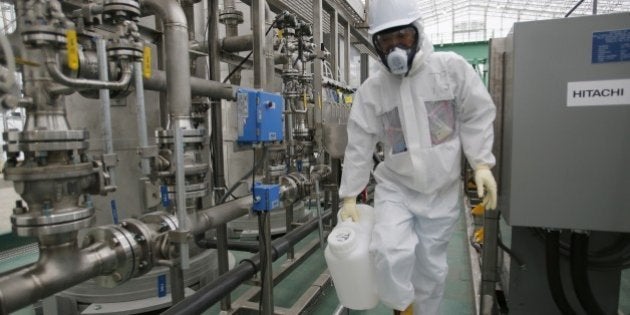 A Tokyo Electric Power Co. (TEPCO) worker wearing radioactive protective gear works on the back area of Advanced Liquid Processing Systems, known as ALPS at the Fukushima Dai-ichi nuclear power plant in Okuma, Fukushima Prefecture, northeastern Japan on November 12, 2014. The final obstacle to restarting two nuclear reactors in Japan was removed on November 7 when local politicians granted approval for a plant to go back online, more than three years after the Fukushima disaster. AFP PHOTO / POOL / Shizuo Kambayashi (Photo credit should read SHIZUO KAMBAYASHI/AFP/Getty Images)