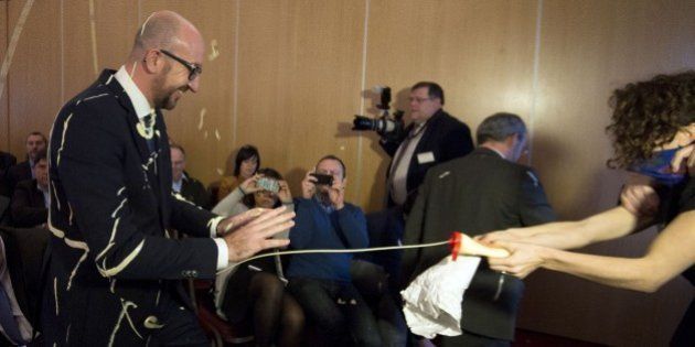 Belgian Prime Minister Charles Michel (L) reacts as activists throw fries and mayonnaise on him during an anti-government protest by feminist activist group LilithS (formerly the Belgian branch of Femen) at a press conference at the Cercle de Wallonie in Namur on December 22, 2014. AFP PHOTO / BELGA / LAURIE DIEFFEMBACQ== BELGIUM OUT == (Photo credit should read LAURIE DIEFFEMBACQ/AFP/Getty Images)