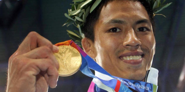 Athens, GREECE: Japan's Tadahiro Nomura shows his gold medal after winning the men's under 60 kg judo final, 14 August 2004 at the Ana Liosia Olympic Hall in Athens, at the 2004 Olympic Games. AFP PHOTO FRANCK FIFE (Photo credit should read FRANCK FIFE/AFP/Getty Images)