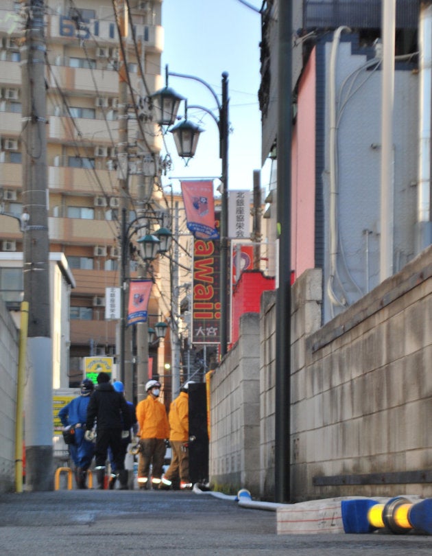 火災のあった風俗店を現場検証する警察と消防＝１８日、さいたま市大宮区 