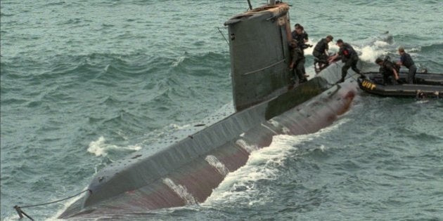 South Korean soldiers take to a North Korean submarine which was found stranded on a reef on South Korea's east coast at Kangnung, northeast of Seoul, Wednesday, Sept. 18, 1996. One North Korean intruder was captured and 11 others were found dead after abandoning the submarine according to the Defense Ministry. (AP Photo/Ahn Young-joon)