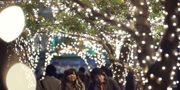 A couple walks through part of Christmas illuminations, lit by 280,000 LED lights, at Tokyo Midtown business and commercial complex in Tokyo, Saturday, Dec. 21, 2013. (AP Photo/Koji Sasahara)