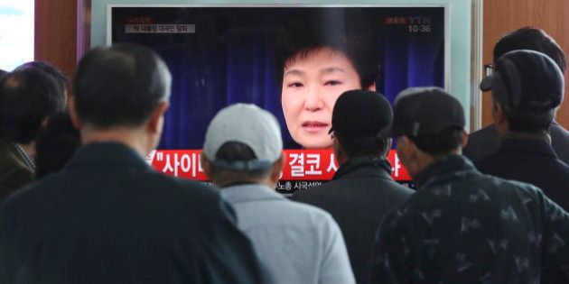 People watch a TV screen showing the live broadcast of South Korean President Park Geun-hye's addressing to the nation, at the Seoul Railway Station in Seoul, South Korea, Friday, Nov. 4, 2016. Park took sole blame Friday for a