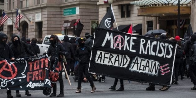 Demonstrators walk through the street before the inauguration of President-elect Donald Trump January 20, 2017 in Washington, DC. Donald Trump was sworn in as the 45th president of the United States Friday -- capping his improbable journey to the White House and beginning a four-year term that promises to shake up Washington and the world. / AFP / ZACH GIBSON (Photo credit should read ZACH GIBSON/AFP/Getty Images)