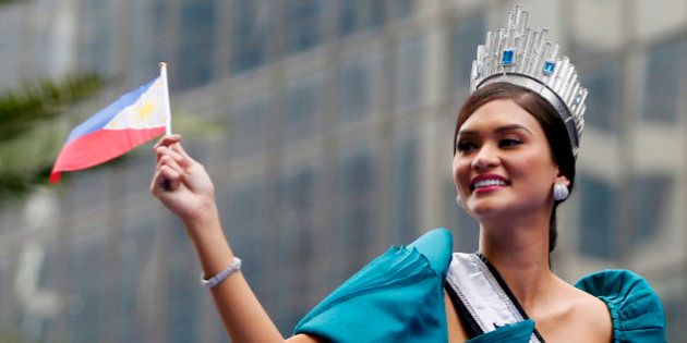 Newly crowned Miss Universe Pia Alonzo Wurtzbach waves a Philippine flag as her float passes by the financial district of Makati city east of Manila, Philippines for a victory parade Monday, Jan. 25, 2016. Wurtzbach was crowned Miss Universe Dec. 20, 2015 but not before pageant host Steve Harvey incorrectly announced Miss Colombia as the winner at the Miss Universe pageant in Las Vegas. Thousands of Filipinos lined the parade route to take a glimpse of the third Filipino to be crowned Miss Universe. (AP Photo/Bullit Marquez)