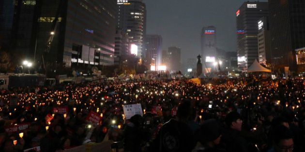 South Korean protesters hold up candles during a rally calling for South Korean President Park Geun-hye to step down in Seoul, South Korea, Saturday, Nov. 19, 2016. For the fourth straight weekend, masses of South Koreans were expected to descend on major avenues in downtown Seoul demanding an end to the presidency of Park, who prosecutors plan to question soon over an explosive political scandal. (AP Photo/Lee Jin-man)
