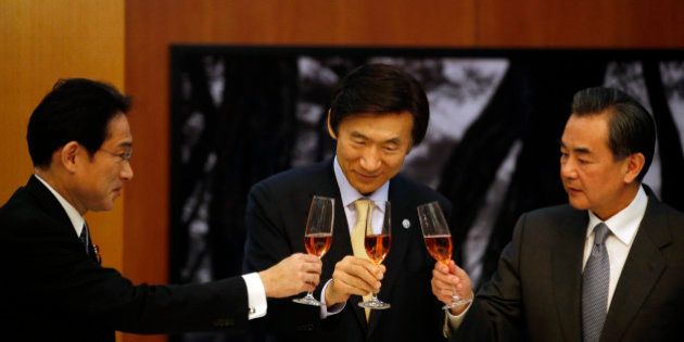 From left, Japanese Foreign Minister Fumio Kishida, South Korean Foreign Minister Yun Byung-se and Chinese Foreign Minister Wang Yi make a toast during a banquet at the South Korean Foreign Minister's residence in Seoul, South Korea Saturday, March 21, 2015. Meeting for the first time in three years, the foreign ministers of South Korea, China and Japan agreed Saturday to work together to improve ties strained over historical and territorial issues and restore trilateral summit talks among their leaders. (AP Photo/Kim Hong-ji, Pool)