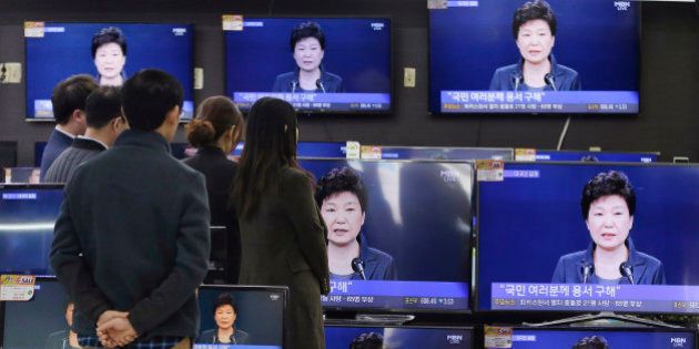 In this Friday, Nov. 4, 2016 photo, people watch TV screens showing the live broadcast of South Korean President Park Geun-hye's addressing to the nation at the Yongsan Electronic store in Seoul, South Korea. Park took sole blame Friday for a