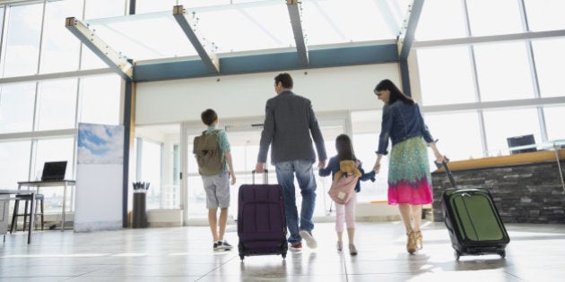 Family with suitcases leaving airport