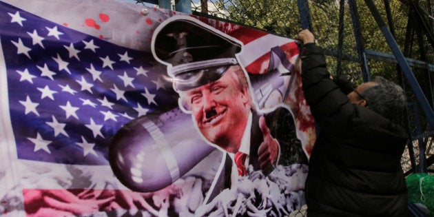 A demonstrator puts a banner with an image depicting U.S. President-elect Donald Trump as he takes part in a protest against Trump, outside the U.S. embassy in Mexico City, Mexico November 14, 2016. REUTERS/Henry Romero